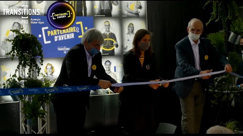 Copie d'écran représentant Claude Bost, Maurice Croppi, vice-président et président de Transitions Pro Auvergne Rhône-Alpes, Camille Augey, adjointe au maire de Lyon en charge de l’Emploi et de l’économie durable, inaugurent les nouveaux locaux de l’association paritaire (2 décembre, Lyon)