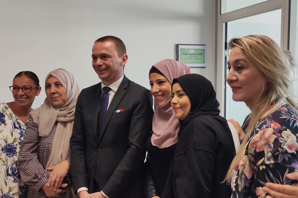 Photo d'Olivier Dussopt, ministre du travail, du plein emploi et de l'insertion, entouré de participantes à l'atelier Talent'Elles, lors de l'inauguration du Village des Solutions Manu'Village (Vénissieux, 22 septembre 2022)