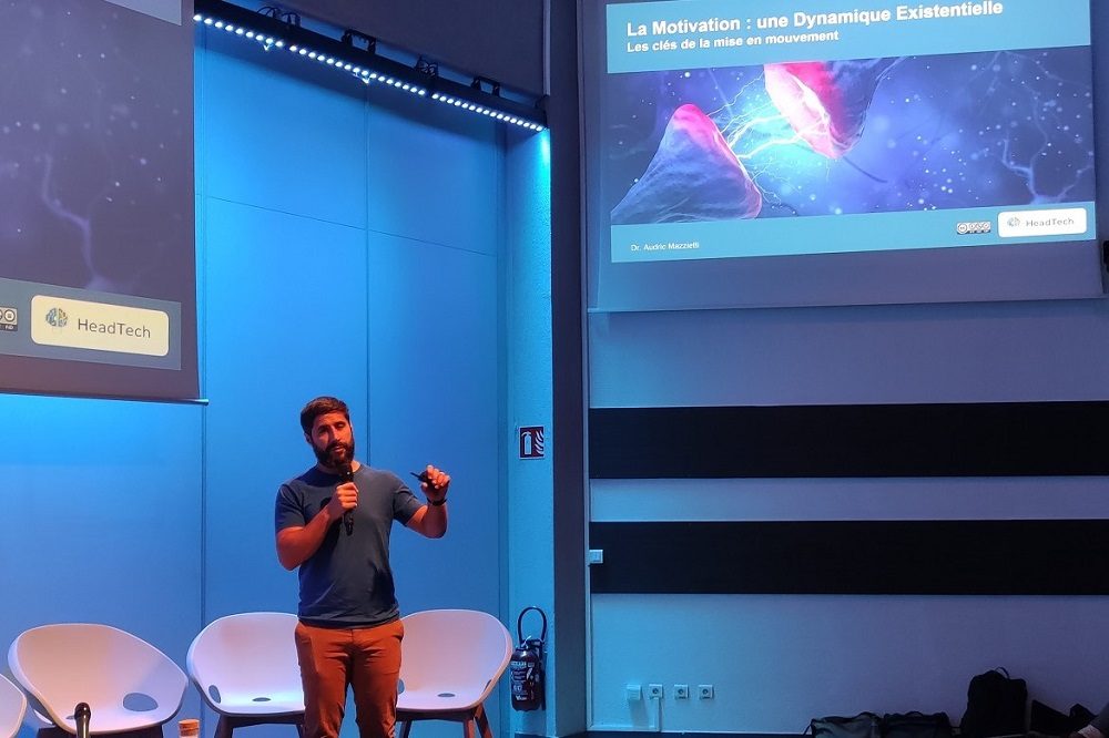 Sur scène, photo d'Audric Mazietti, docteur en psychologie cognitive, enseignant-chercheur en psychologie et responsable digital learning de l'Esdes Lyon business school, lors des Rencontres nationales des Mife (20 juin 2023, Lyon)