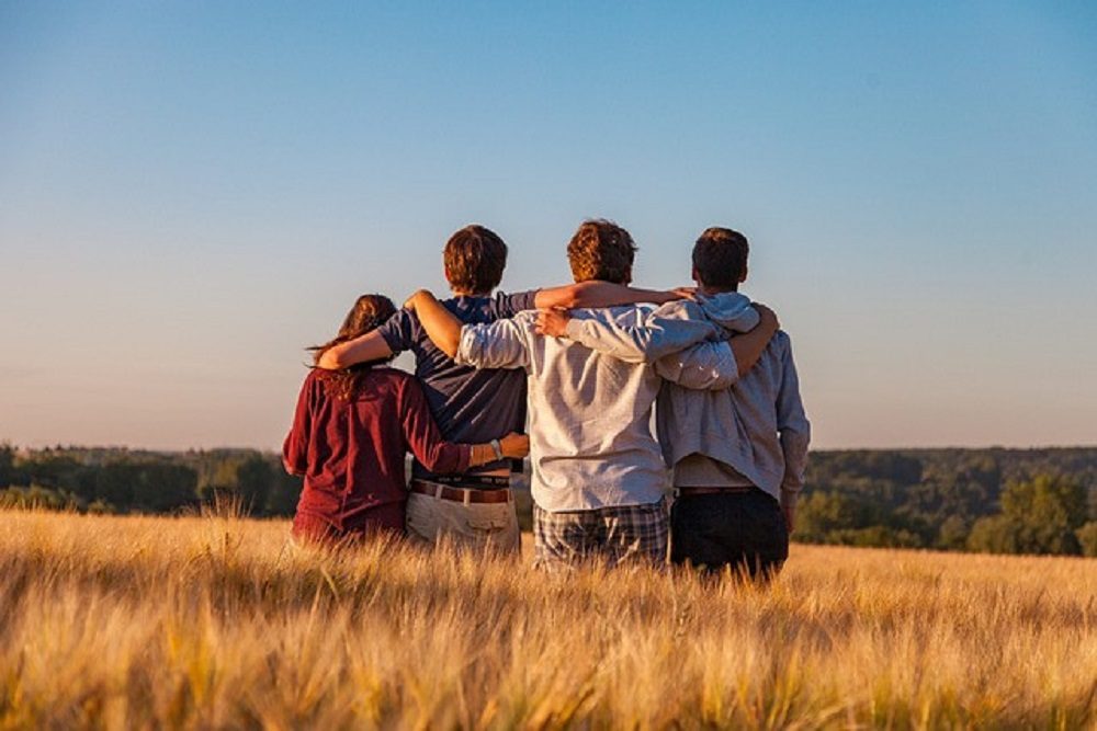 Un groupe de jeunes, de dos, dans un champ